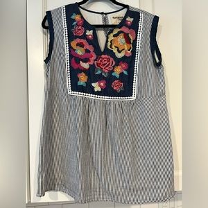 Sleeveless seer sucker top with embroidered flowers.